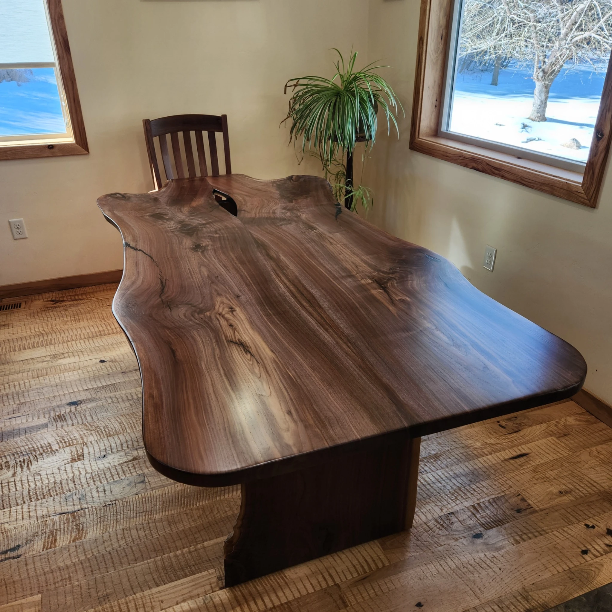 Live-edge walnut dining table showing natural grain and an open knot